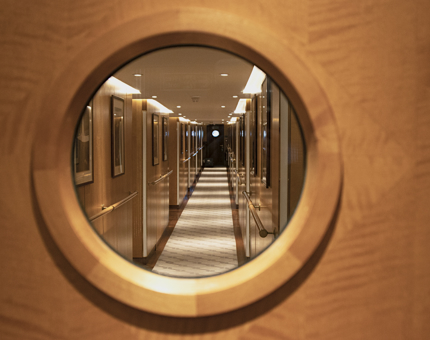 The view through a porthole glass door along the passageway where Fingal's luxury cabins are located.