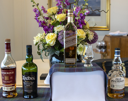 A display of different types of whiskey on the piano in the Tea Room.