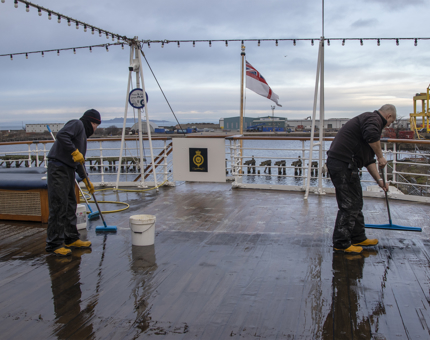 Maintenance men cleaning the Verandah Deck. 