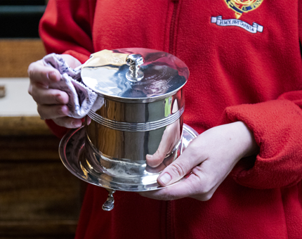 Housekeeper polishing silver. 