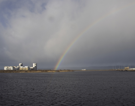 A rainbow in a dark cloudy sky over the Firth in Leith. 