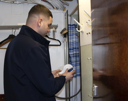 Maintenance man disinfecting shower heads. 