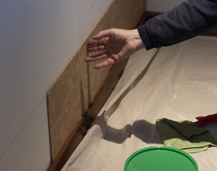 A close-up of a man fitting the cork panels in place from the previous picture. 