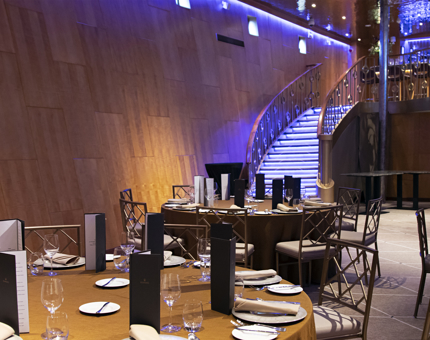 The interior of the Ballroom at Fingal showing the curved sweeping staircase, curved walls and tables set for dinner with cutlery, glasses and menus. 