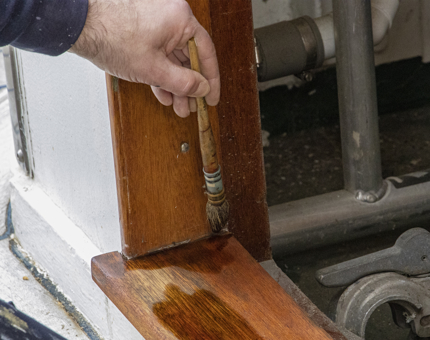 A close-up look at the man holding a varnish brush. 