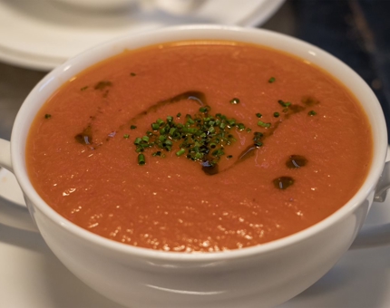 A close up of a bowl filled with roasted vine tomato and pepper soup.