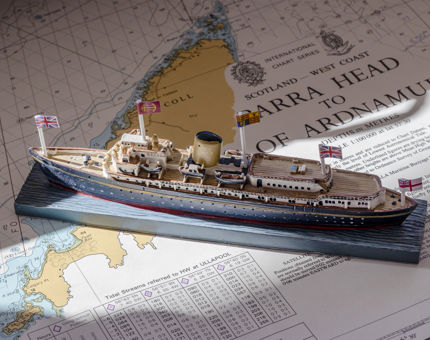A small scale Britannia model sits on a map of the West Coast of Scotland. 