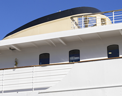 A bright blue sky in the morning and the exterior of Fingal's Bridge and cabin windows on the deck below. 