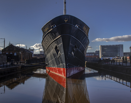The view of the bow of Fingal reflected in the water and a blue sky with only a few clouds. 