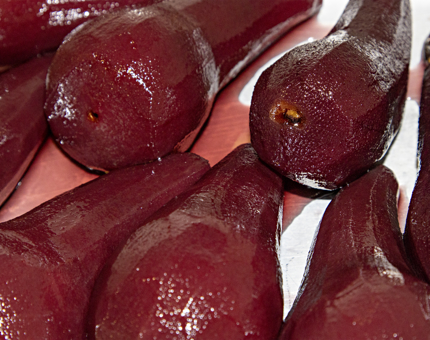 A close-up view of pears soaking in red wine.