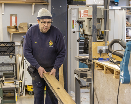 A man from the Maintenance team planing handrails for Fingal.