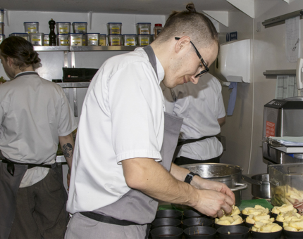 A Chef making apple tarte tatin in the Galley.