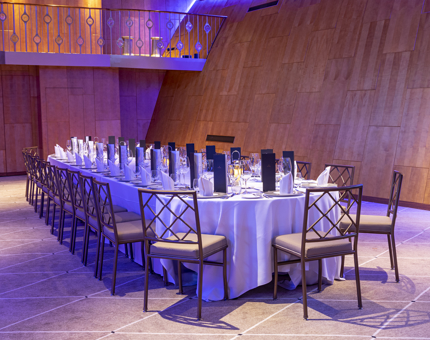 Fingal's Ballroom is beautifully lit with soft purple lighting. Tables are set for dinner.