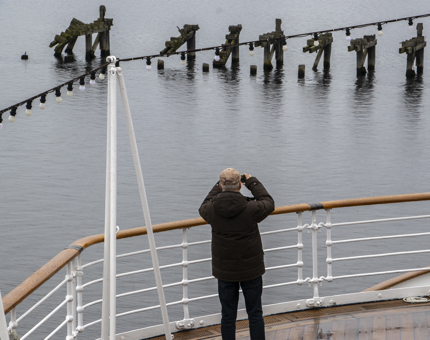 A visitor standing on deck taking a photograph of Leith Docks.