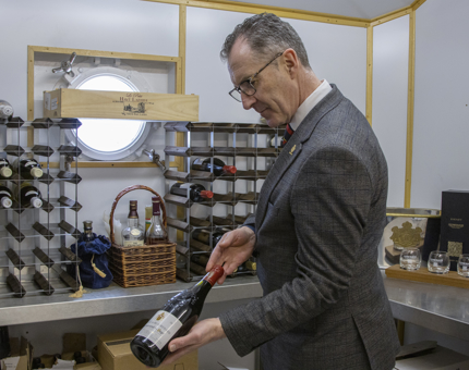 The Private Dining Manager selects a bottle of wine from the wine store. 