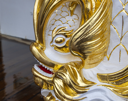 A close-up detail of the gold leaf on the ornate compass binnacle. 