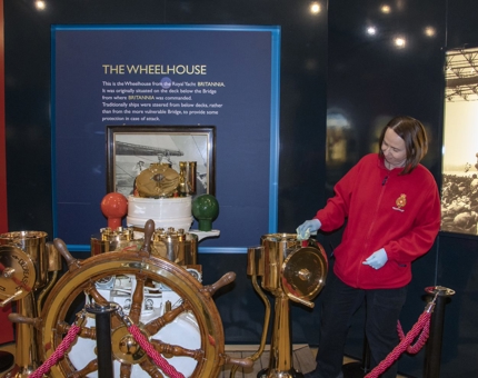Renata, Housekeeper, polishing the wheelhouse in the Visitor Centre.