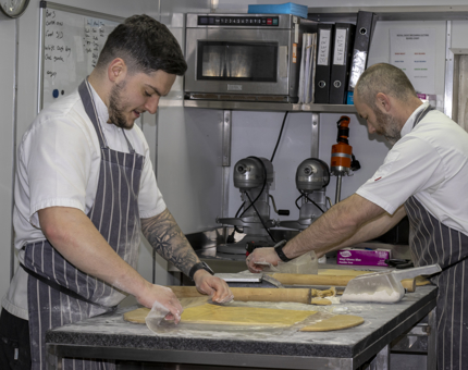 Bob, Junior Sous Chef, and Stephen, Executive Pastry Chef, laminating brioche in the Pastry Galley.