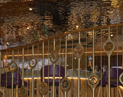 The Ballroom bar onboard Fingal showing the nautical detail of the balcony and shimmering copper ceiling. 