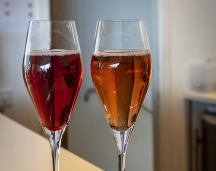 A close-up of two drinks; a Kir Royale and and a Dubonnet cocktails. 