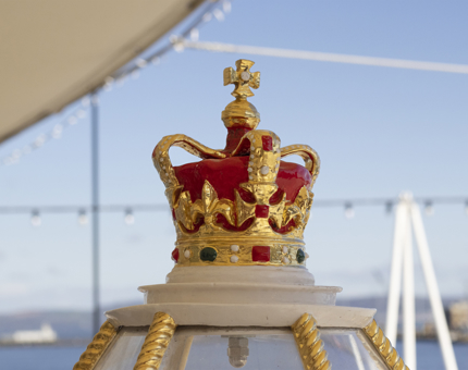 The ornamental painted crown on top of the decorative compass binnacle.