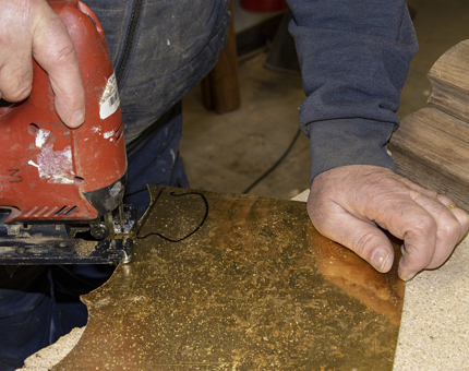 Brass cap ends are cut with a piece of machinery in the workshop. 