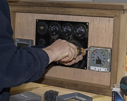 A man fits new dials to a console on Bloodhound. 