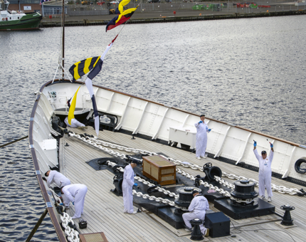 A group of six former Royal Yachtsmen painting on the Foc's'le deck, the forward part of Britannia.