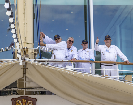A group of smiling Yotties tightening the aft dressing line.
