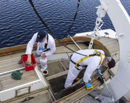 Two Yotties cleaning one of the Jolly Boats.