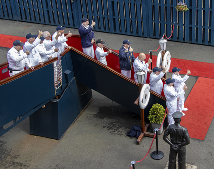 Yotties standing on the Royal Brow give a thumbs up next to the red carpet. 