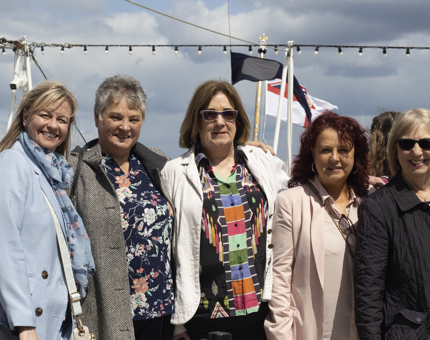 A group of five ladies posing for a photograph on Britannia's Verandah Deck.