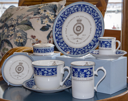 The 70th anniversary of Britannia collection of china displayed in the Sun Lounge. A blue and white plate, teacups and saucers, coffee mug and a trinket box. 