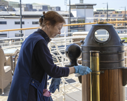 A Housekeeper cleaning the binnacle on Fingal. 