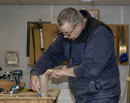 A member of the Maintenance team marks out the brass end for the handrails. 
