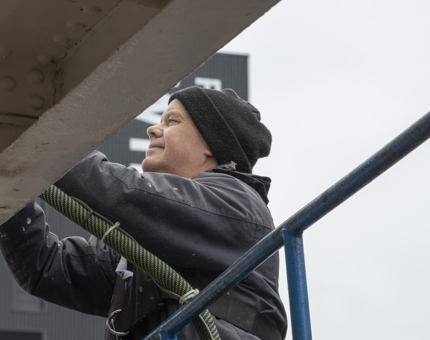 A man sanding the skirting plate outside Britannia. 