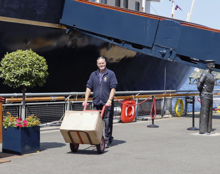 A man wheels a trolley on the Quayside. 