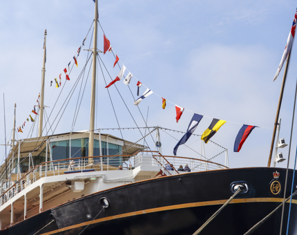 The exterior of the stern at Britannia with the dress flags billowing in the wind. 