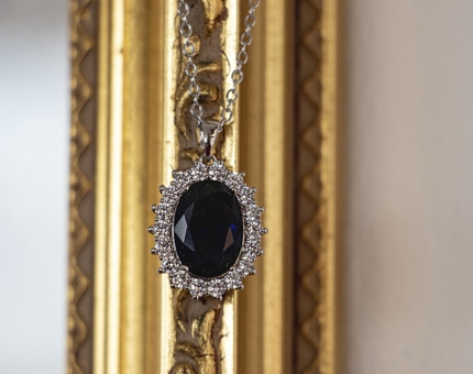 A pendant necklace containing a dark blue stone. 