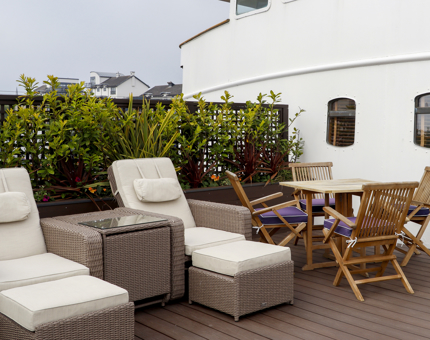 The private outside deck of the Skerryvore Suite at Fingal, with sunloungers, a table and chairs. 