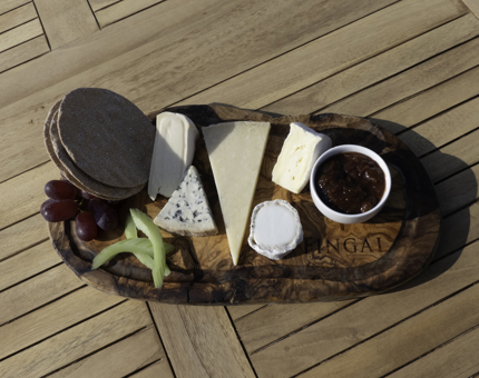 A cheeseboard containing a selection of cheeses, chutney and crackers.