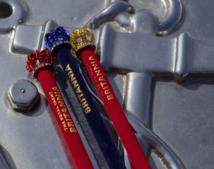 Three crown-topper pencils, two red and one blue. 