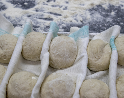 A tray of fresh dough bread rolls. 