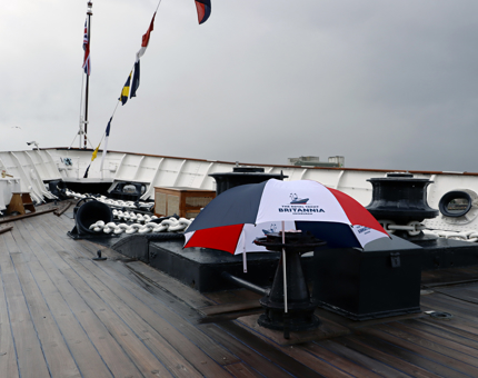 A red, white and blue umbrella on the Fo'c's'le deck on a rainy day.
