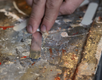 A close up of a hand removing a name plaque from a trophy stand. 