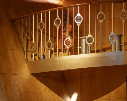 The gold Musicians' Gallery at Fingal. A double bass is sitting behind the gold railings.