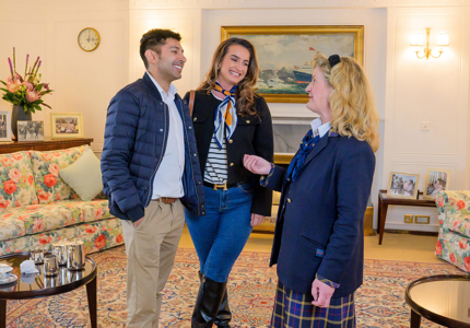 A man and a woman talking to a Visitor Assistant in the Drawing Room.