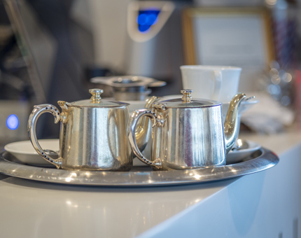 A silver tray with silver teapots. 