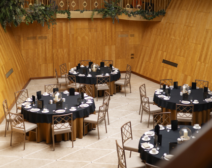 The Ballroom on Fingal, there are 4 tables with black table cloths set for a dinner.