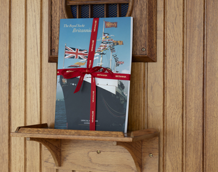 A Britannia guidebook on a shelf. 